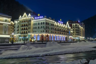 Rusya, Soçi, Krasnaya Polyana. Rosa Khutor, oteller ve mağazalar kış geceleri Mzımta nehirde beldesi. 23 Aralık 2016.