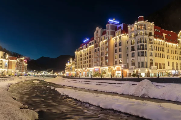 Rusya, Soçi, Krasnaya Polyana. Rosa Khutor, oteller ve mağazalar kış geceleri Mzımta nehirde beldesi. 23 Aralık 2016.