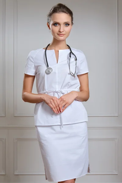 Piękne kobiece kobieta lekarz w białe szaty. Portret z atrakcyjnych — Zdjęcie stockowe