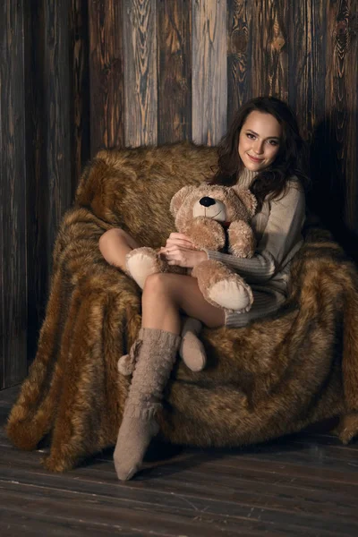 Cute girl in knee socks and sweater with Teddy bear in her hands