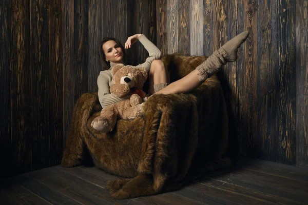 Cute girl in knee socks and sweater with Teddy bear in her hands