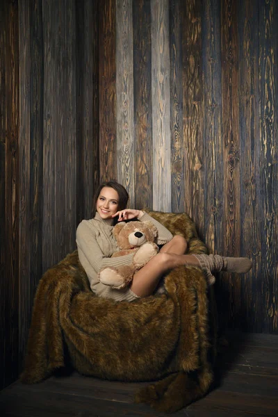 Cute girl in knee socks and sweater with Teddy bear in her hands