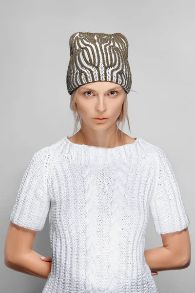 Pretty fashion model in white sweater and knitted hat — Stock Photo, Image