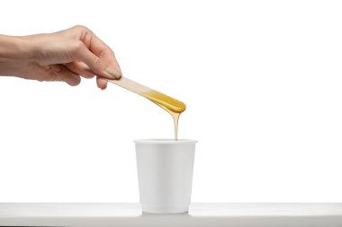 Tahta spatula doun devam akan üzerinde güzellik mum tutan el