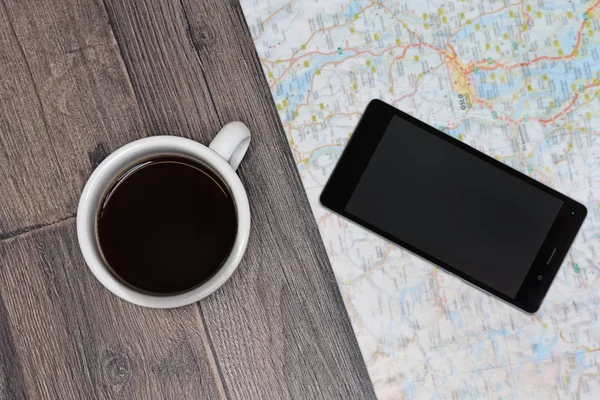Travel. Traveling map on the table. Cup of coffe and smartphone.