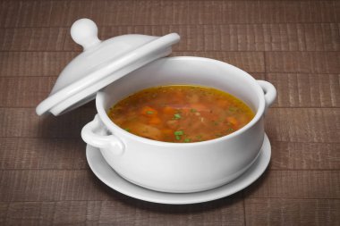 Lahana çorbası ahşap masa üzerinde seramik tencerede bölümünü