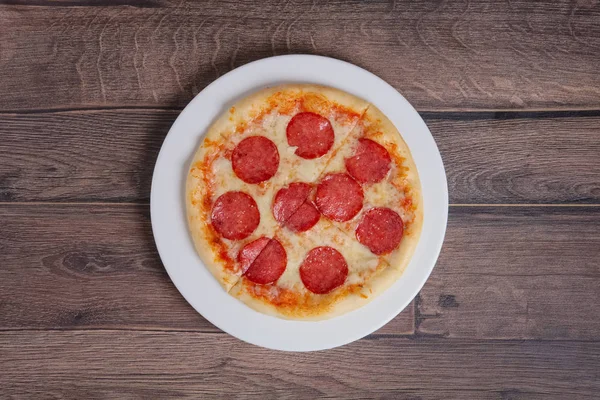 Верхняя точка зрения пиццы пепперони на деревянной тарелке — стоковое фото
