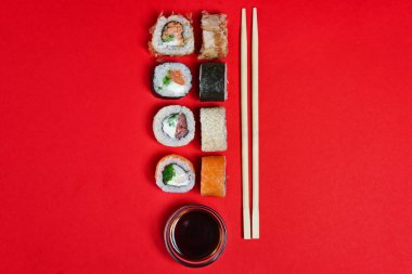 Somon rulo, soya sosu ve çubuk kırmızı zemin üzerine