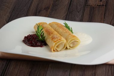 Ahşap masa üstünde sos ile rulo et krep