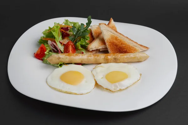 Fried eggs with homemade sausage, toasts and fresh tomato and sa — Stock Photo, Image