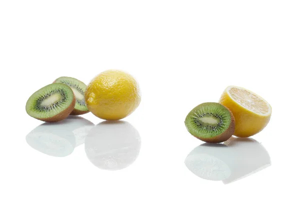 Cytryny i kiwi z refleksji nad stół szkło biały — Zdjęcie stockowe