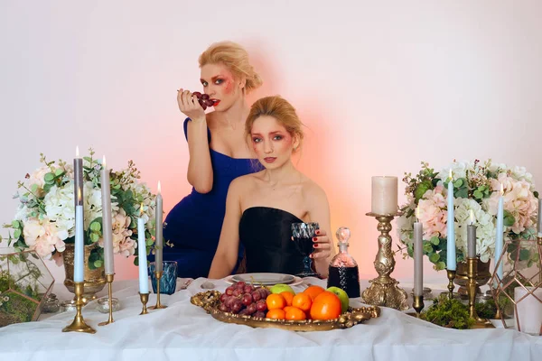 İki meyve, mumlar ve kazanmak masanın arkasında modelleri moda — Stok fotoğraf