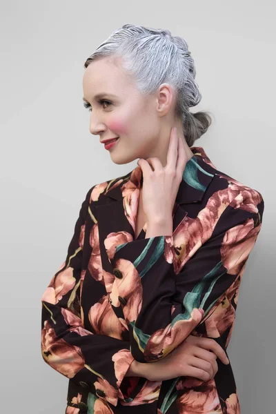 Portrait of young beautiful woman with fancy make-up and grey po — Stock Photo, Image