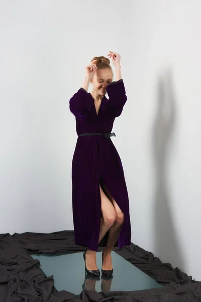 Happy girl dancing in velvet bathrobe near white wall on glass p — Stock Photo, Image