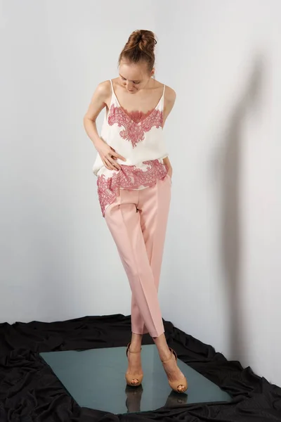 Модна модель в персикових тонких штанах і блузка з мереживом на ремінцях — стокове фото