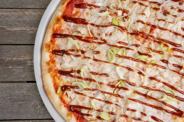 Top view of part of pizza with chicken barbecue on wooden table. — Stock Photo, Image