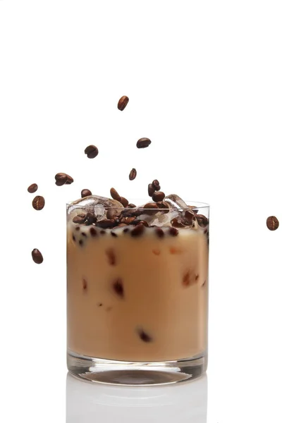 Granos de café cayendo en cóctel con licor de crema irlandesa en un — Foto de Stock