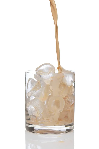 Liquore irlandese alla panna versato in un bicchiere pieno di ghiaccio . Immagini Stock Royalty Free