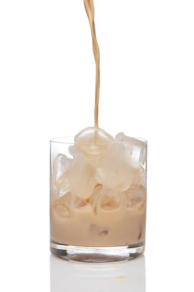 Irish creme liqueur pouring in a glass full of ice. Royalty Free Stock Images
