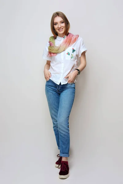 Bella ragazza in jeans arrotolati, scarpe da ginnastica e sciarpa di seta colorata — Foto Stock