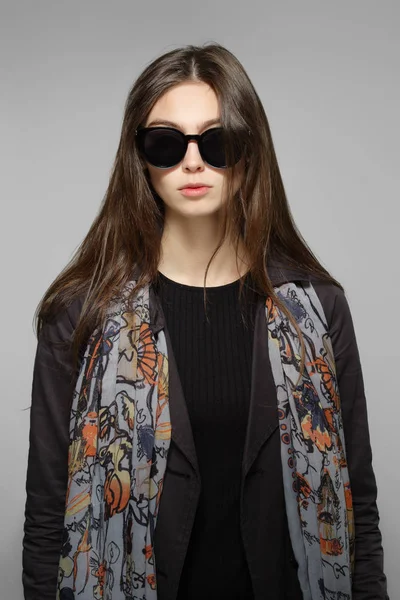 Красивая девушка с длинными волосами в больших солнцезащитных очках, открытым пальто и шрамом — стоковое фото