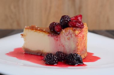 Parçası cheesecake ile kiraz, çilek ve böğürtlen decorat