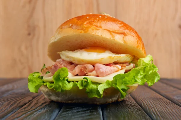 Leckerer Eierburger mit Mozzarella, Salat und gebratenem Speck — Stockfoto