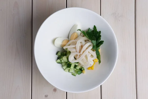 Верхний вид салата с кальмарами, кукурузой, рисом, яйцом и свежим огурцом — стоковое фото