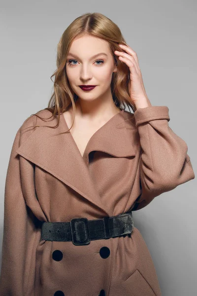 Mooi model in warme wollen jas tot vaststelling van haar. — Stockfoto