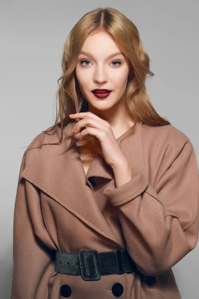 손으로 그녀의 턱 가까이 따뜻한 모직 코트에 예쁜 모델. — 스톡 사진