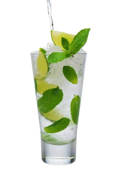 Pouring tonic into highball glass with ice crush, mint and lime — Stock Photo, Image