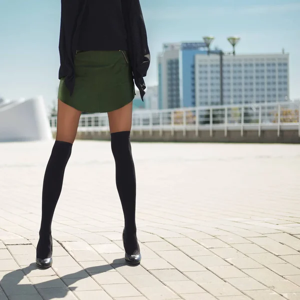 Pernas femininas magras longas em meias de joelho em cima de collants e curto l — Fotografia de Stock