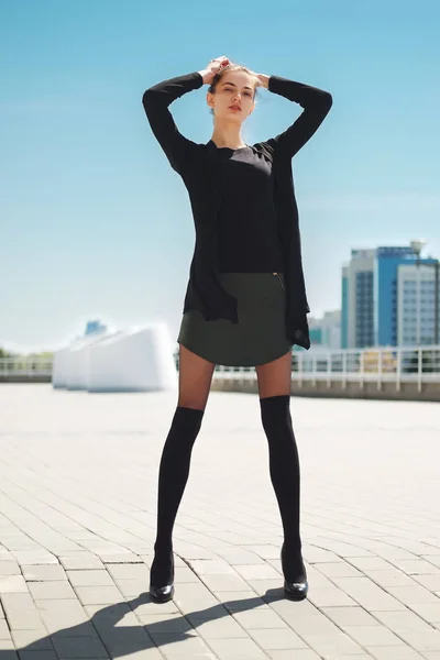 Slim girl in short leather skirt and legs with knee socks on top — Stock Photo, Image