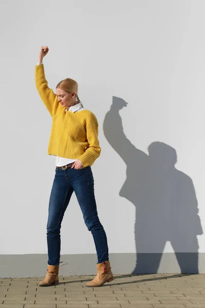 Menina posando perto na frente da parede com sombra engraçada sobre ele. Moda de rua . — Fotografia de Stock