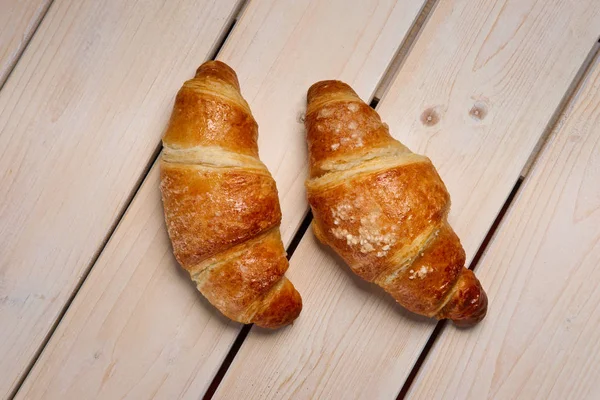 A pair of fresh croissant on the table, top view. — Stock Photo, Image