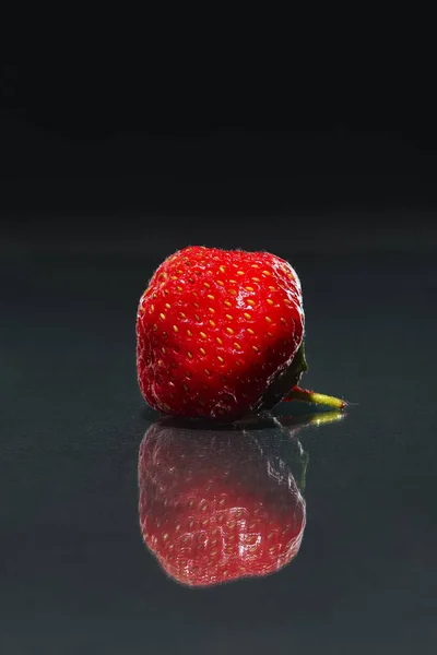 Fresa fresca con reflexión sobre vidrio sobre fondo oscuro — Foto de Stock