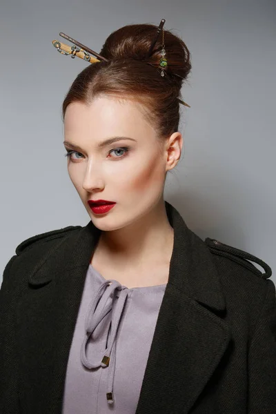 Portrait of model with oriental hairstyle, red lips and blue eye