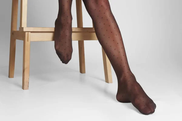 Выборочное фото женских ног в прозрачных колготках с классическим рисунком в горошек — стоковое фото