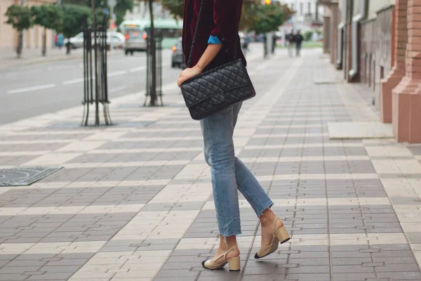 Vista lateral da mulher em jeans e casaco na rua com saco (foto foco suave ) — Fotografia de Stock