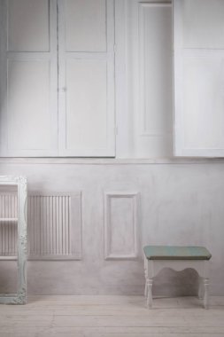 Pencere kapalı panjurlar, yumuşak sandalye ve raf ile