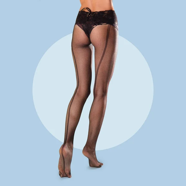 Lange slanke vrouwelijke benen in visnet panty met veter op taille — Stockfoto