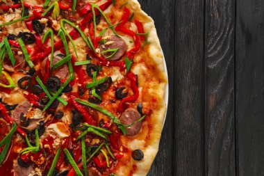 Sosis ve soğancık lezzetli pizza üstten görünüm koyu ahşap arka plan üzerinde