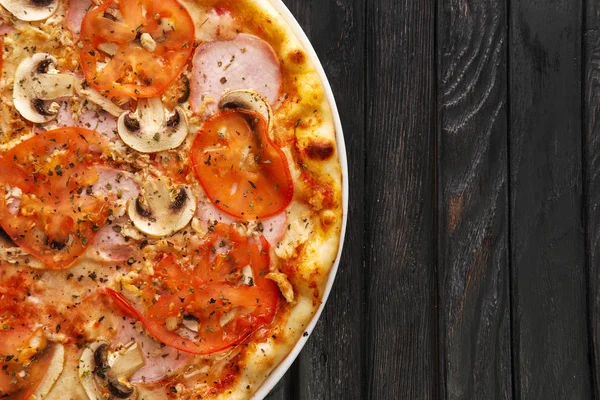 Koyu ahşap zemin üzerine lezzetli Pizza jambon ve mantar ile Üstten Görünüm