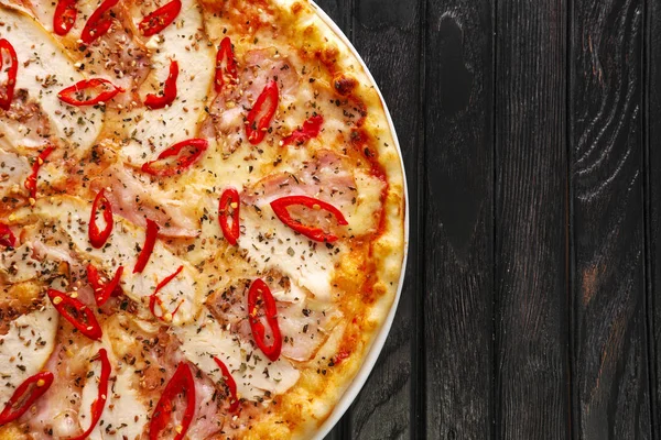 Koyu ahşap zemin üzerine lezzetli sıcak biber pizza Üstten Görünüm