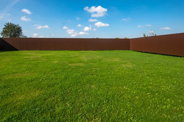 Bir oluklu metal çitle çevrili çim