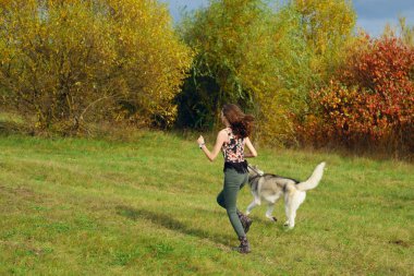 Şehir Parkı husky köpek ile oynayan kız. Köpek ile jogging.