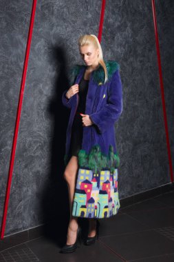 Çekici kız kısa siyah elbise, soğuk soğuk duvara yakın poz uzun kürk manto