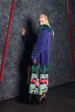 Çekici kız kısa siyah elbise, soğuk soğuk duvara yakın poz uzun kürk manto