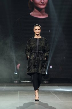 Arka plan üzerinde online ekran ile güzel manken kürk manto pist yürür