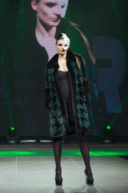 Arka plan üzerinde online ekran ile güzel manken kürk manto pist yürür